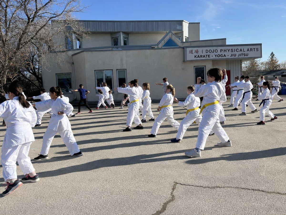 The dojo from outside — DOJO Physical Arts in Charleswood, Winnipeg, with a karate class training in the lot